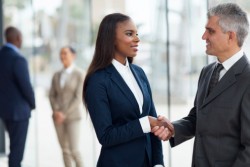 senior businessman handshaking with young businesswoman